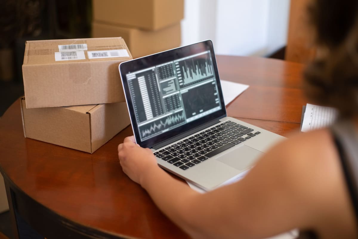 Laptop on a table next to stacked cardboard boxes during an office move